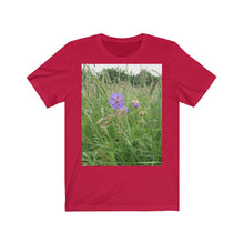 Load image into Gallery viewer, Photograph of a meadow cranesbill flower printed onto a red T-Shirt.