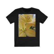 Close up photograph of two yellow lily's printed onto a black T-Shirt.